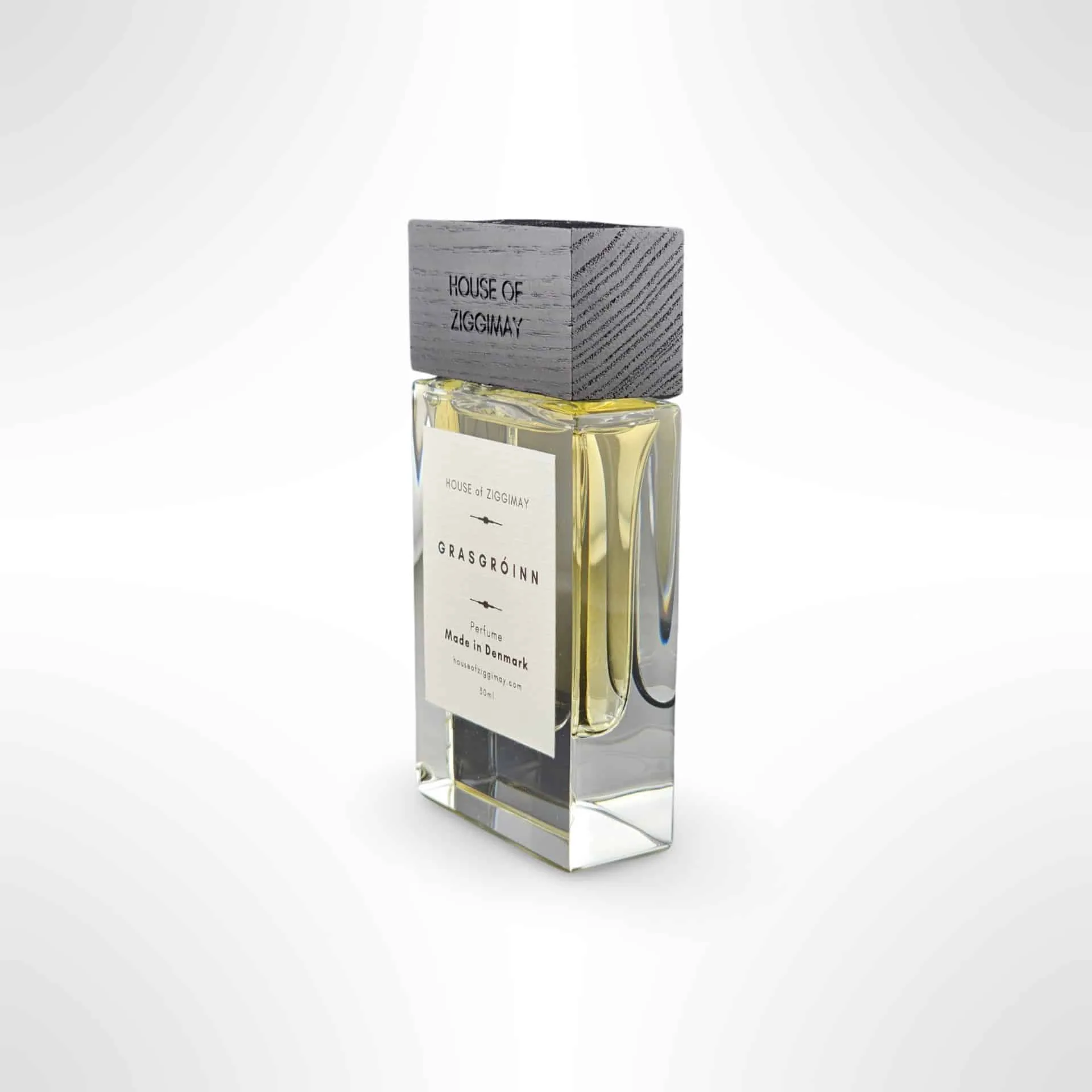 A perfume bottle marked House of Zosimos is set against a light gray background. The bottle, topped with a wooden cap, contains a yellow liquid. An elegant label displays Grasgróinn and Made in Denmark, encapsulating the essence of refined fragrance artistry.