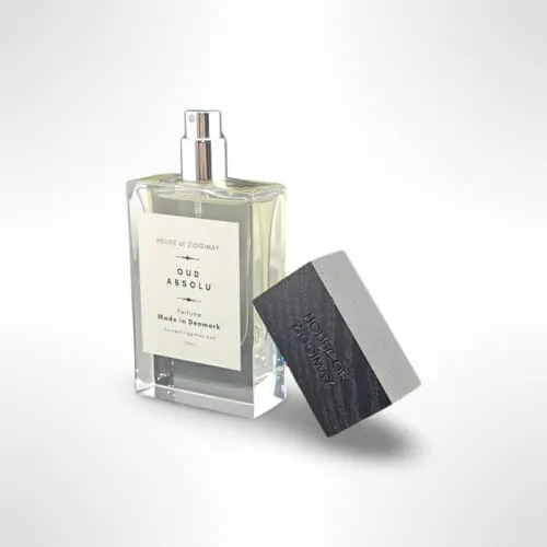 Homepage A variety of elegant perfume bottles in different shapes, sizes, and shades of pink, gold, and clear glass are arranged on tiered white shelves, reflected on a glossy surface perfect for exploring perfume layering or discovering your signature scent.