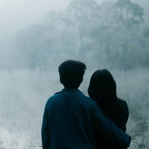 Patchouli in Perfume a man and a woman standing in front of a body of water
